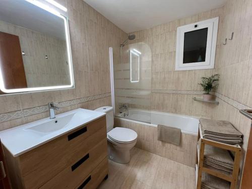 W łazience znajduje się umywalka, toaleta i lustro. w obiekcie Acogedor piso en Terrassa w mieście Terrassa