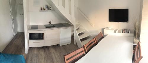 een woonkamer met een keuken met een wastafel en een tv bij location front de mer Plein Soleil in Le Crotoy