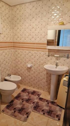 uma casa de banho com um lavatório, um WC e um espelho. em Spacieux appartement au centre-ville de Tanger em Tânger