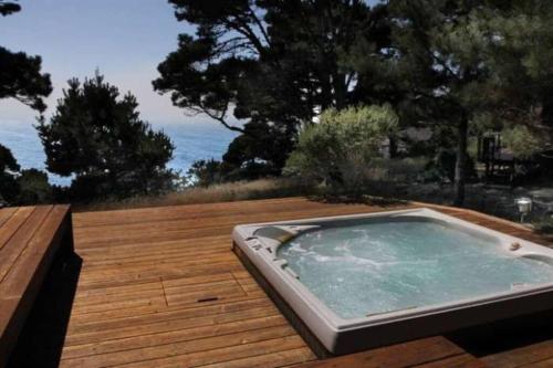 a hot tub sitting on top of a wooden deck at Ocean Bluff Serenity in Walsh Landing