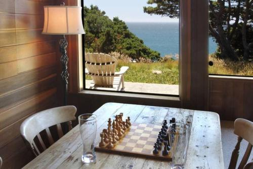 a chess board on a table in front of a window at Ocean Bluff Serenity in Walsh Landing