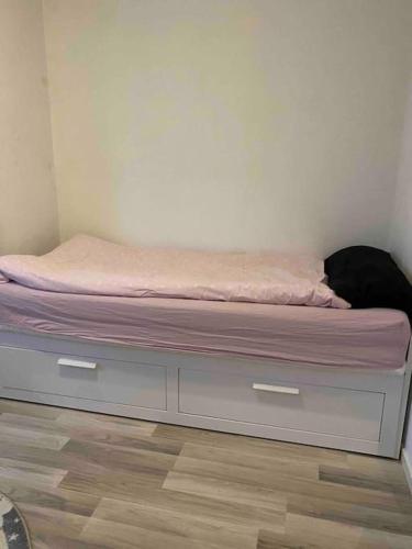 a bed with a pink mattress on top of it at Lantligt hus nära Isaberg in Nissafors