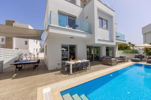 a villa with a swimming pool and a house at Fig Tree Bay Residences 3 in Protaras