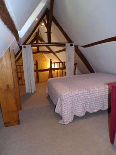 une chambre avec un lit dans un grenier dans l'établissement Gîte rural, proche des sites touristiques, à Gourdon