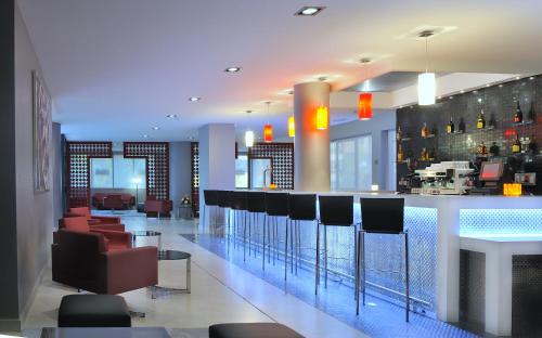 a bar in a hotel with chairs and a counter at Hotel Tent Granada in Granada