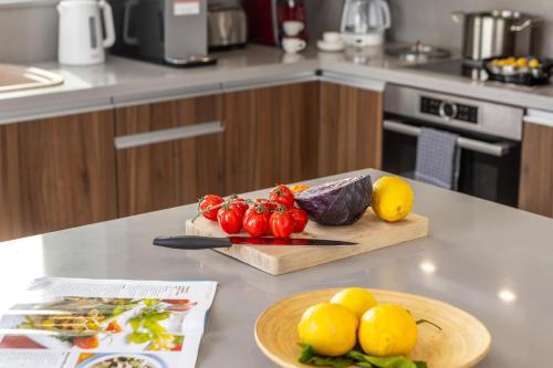 a kitchen counter with a cutting board with tomatoes and lemons at Fig Tree Bay Residences 3 in Protaras