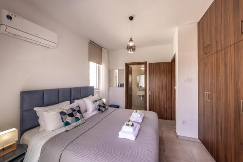 a bedroom with a large bed with towels on it at Fig Tree Bay Residences 3 in Protaras