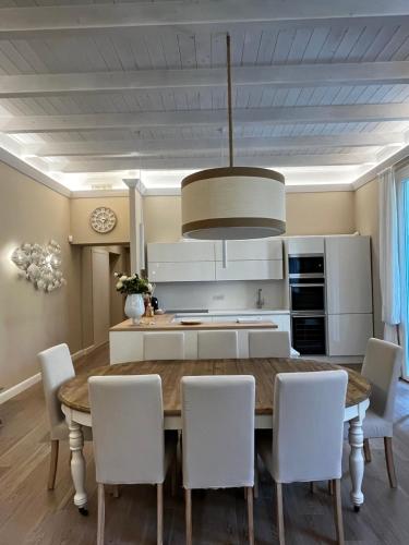 Luxury home Le Sirene في أنزيو: مطبخ مع طاولة خشبية وكراسي بيضاء