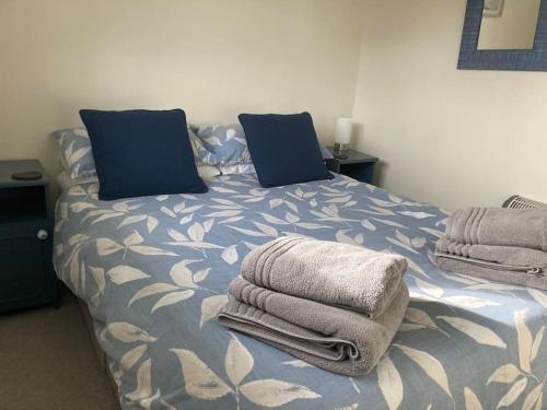 een slaapkamer met een bed met handdoeken erop bij Margaret Ann Chalet in Seaton