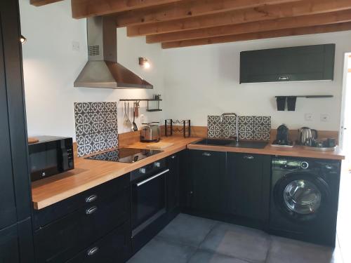 une cuisine avec un évier et une machine à laver dans l'établissement Villa Cocoon, à Saint-Jean-aux-Bois