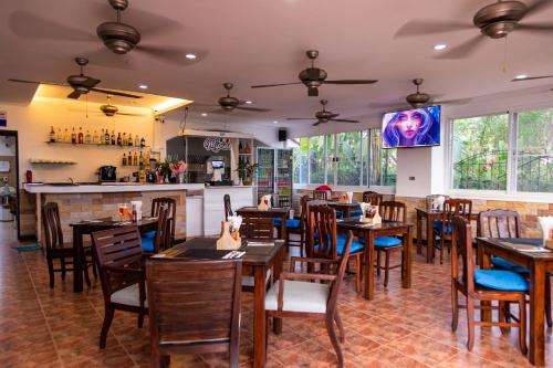 un restaurante con mesas y sillas de madera y un bar en Mipiace, en Kamala Beach