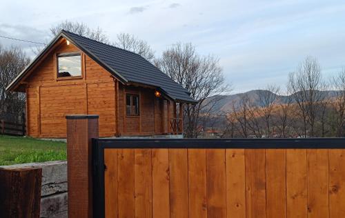 uma pequena casa de madeira com uma cerca de madeira em Brvnara Beli em Gornji Milanovac