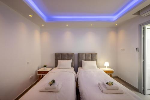 two beds in a room with a blue ceiling at Fig Tree Bay Residences 3 in Protaras