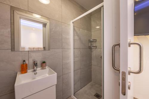 a bathroom with a shower and a sink and a mirror at Fig Tree Bay Residences 3 in Protaras