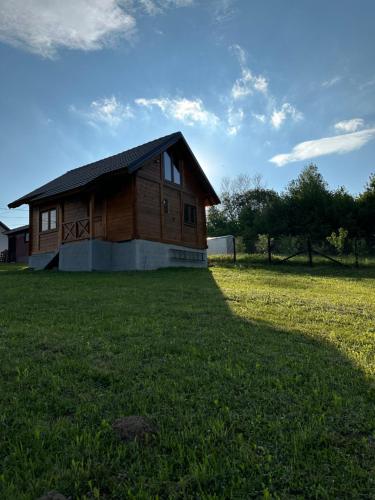 a small wooden house in a field of grass at Brvnara Beli in Gornji Milanovac