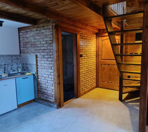 a kitchen with a staircase and a brick wall at Brvnara Beli in Gornji Milanovac