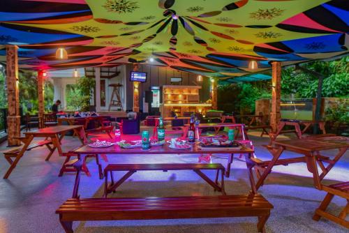a restaurant with tables and chairs under a colorful ceiling at Siyonra Bungalow in Matale