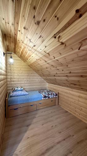 a room with a bed in a wooden room at Domki Na Złotym Groniu in Istebna