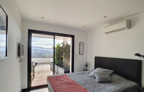 - une chambre avec un lit et une vue sur un balcon dans l'établissement APPARTEMENT PORTICCIO, à Grosseto-Prugna