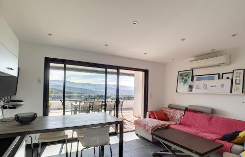 un salon avec un canapé rouge et une table dans l'établissement APPARTEMENT PORTICCIO, à Porticcio