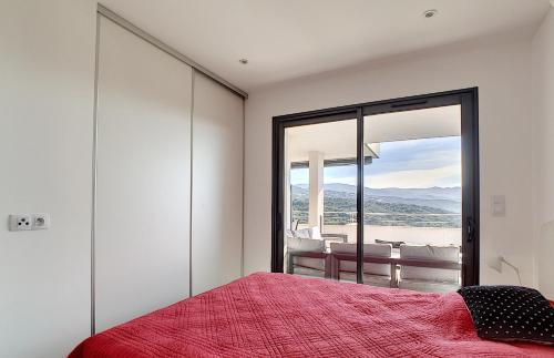 - une chambre avec un lit rouge et une grande fenêtre dans l'établissement APPARTEMENT PORTICCIO, à Grosseto-Prugna