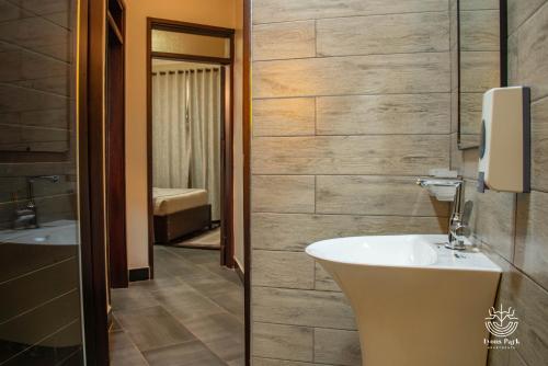 uma casa de banho com um lavatório, um WC e um espelho. em Lyons Park Apartments. em Bulindo