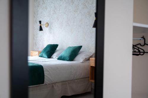a bedroom with a bed with green pillows at El Secreto de Chirinos in Úbeda