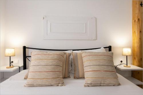 a bedroom with a bed with two pillows and two lamps at Ziv Boutique Apartments Town Square in Lefkada Town