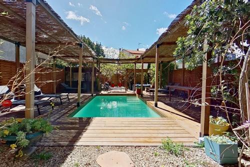 - une piscine dans un jardin avec une pergola dans l'établissement Les 2 Drôles d'Oiseaux, à Luc-sur-Orbieu