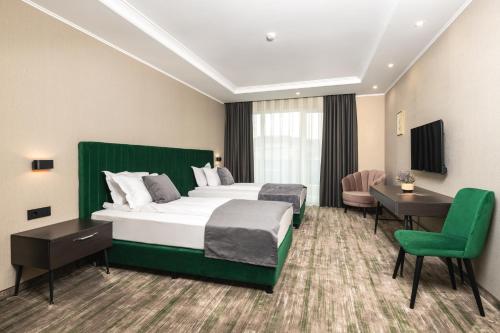 Cette chambre comprend un lit, un bureau et une chaise. dans l'établissement Empire Balneo and Spa Hotel, à Hisarya