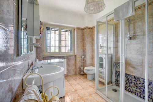 ein Bad mit einer Badewanne, einem WC und einer Dusche in der Unterkunft Residenza Menta e Rosmarino in Perugia