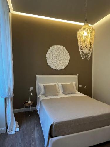 a bedroom with a bed and a chandelier at Luxury home Le Sirene in Anzio