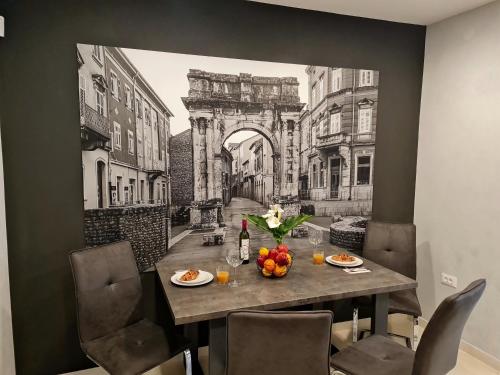 a dining room table with a picture of an archway at Apartment Golden Gate in Pula