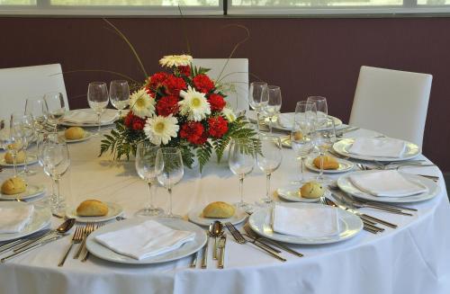 a table with a white table cloth and a vase of flowers at Turia Granada in Granada