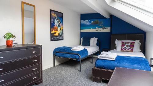 una camera con due letti e un comò di 2 Bed House - Sleeps 6 Perfect for Families and Contractors a Leeds