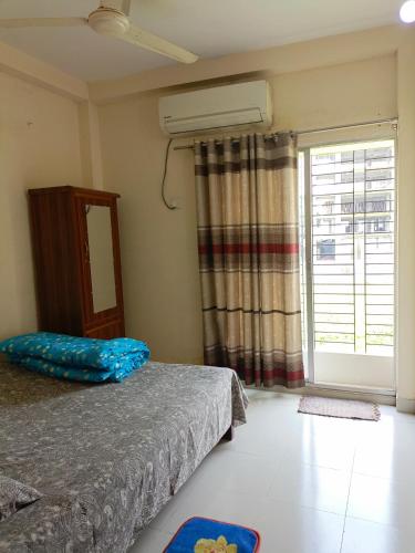 een slaapkamer met een bed en een groot raam bij Star Night stay family Studio AC Apartment in Dhaka