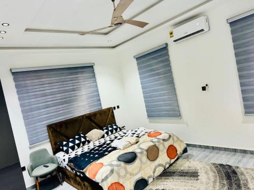 a bedroom with a bed and a ceiling fan at Executive 2bedroom House in Tema