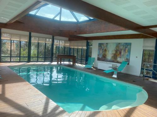 a large swimming pool with blue chairs and a table at L’Hacienda Francesa in Palaja