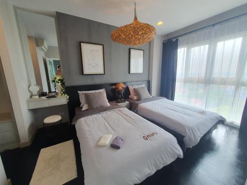 a bedroom with two beds and a chandelier at Prio 机场 in Chiang Mai