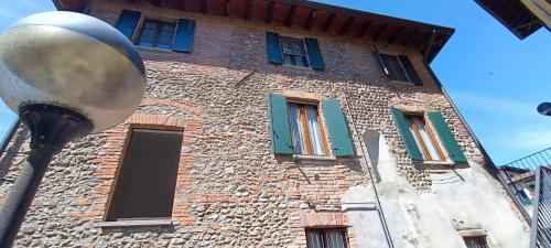 a brick building with green windows and a street light at a casa di Leo in Capriate San Gervasio