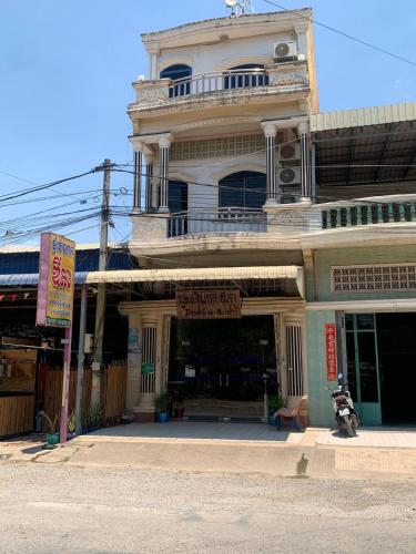 a building with a balcony on top of it at Ditar Guest House D in Battambang