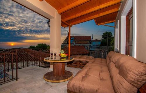 a patio with a couch and a table on a balcony at Pearly Sunset in Maryiés