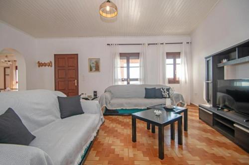 a living room with a couch and a tv at Pearly Sunset in Maryiés
