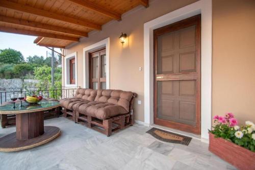 a porch with a couch and a table and a door at Pearly Sunset in Maryiés