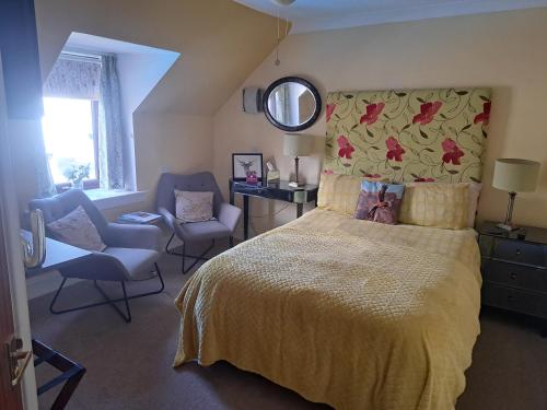 a bedroom with a bed and a chair and a mirror at No 27 in Inverness