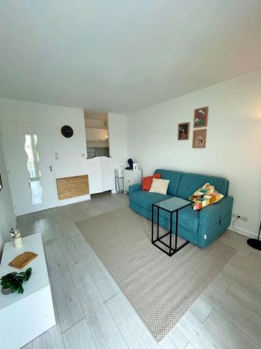 un salon avec un canapé bleu et une table dans l'établissement Studio cozy au cœur de Bordeaux, à Bordeaux