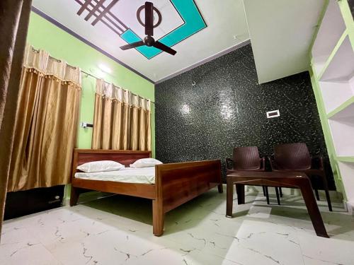 1 dormitorio con 1 cama y ventilador de techo en Sainik Homestay, Ayodhya en Ayodhya