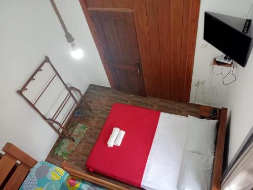1 dormitorio con 1 cama roja y blanca y TV en Barrow Villa en Nuwara Eliya