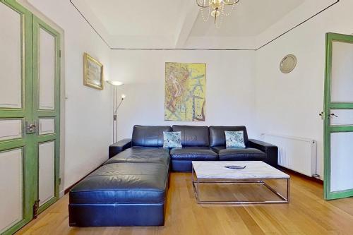 a living room with a leather couch and a coffee table at Les 2 Drôles d'Oiseaux in Luc-sur-Orbieu