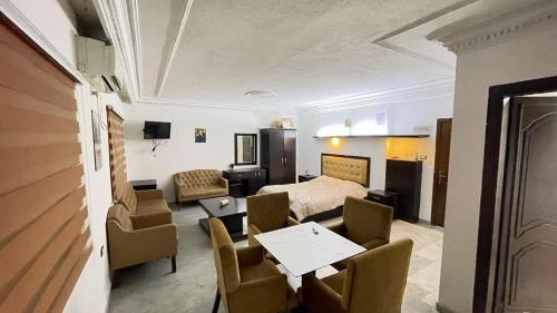 Habitación con cama, mesa y sillas. en aljazeera apartments, en Amán
